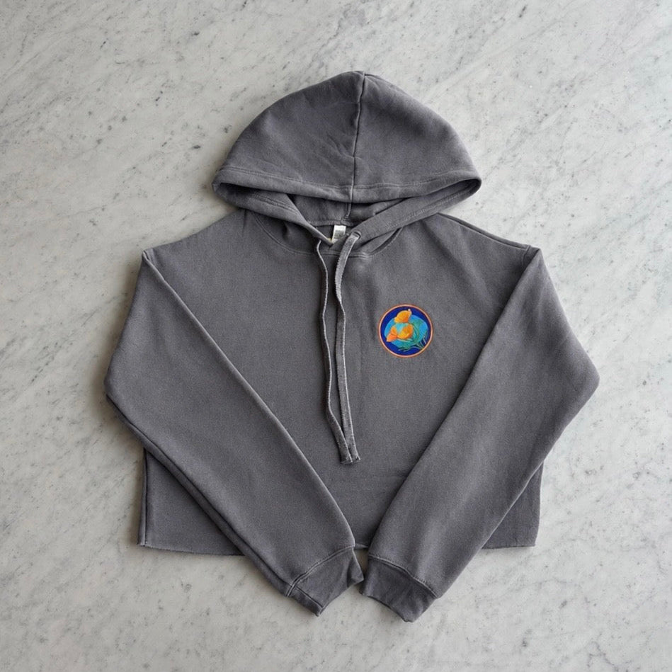 Front of the storm grey Kooh Culture women's cropped fleece hoodie, with the Poppy Power logo on the chest