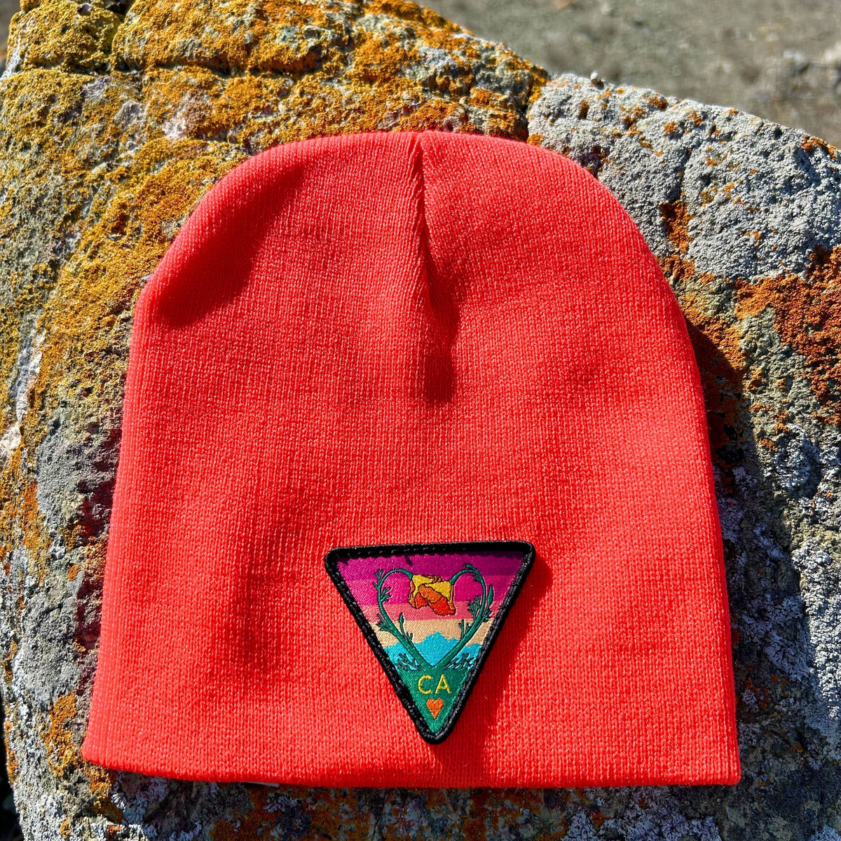 Blaze orange Kooh Culture cuffed beanie with the Poppy CA Love patch