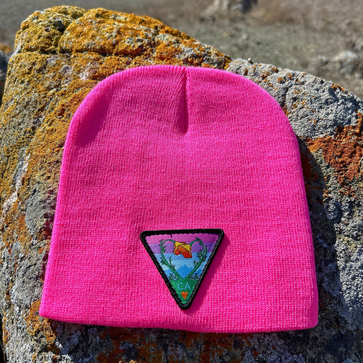 Neon pink Kooh Culture cuffed beanie with the Poppy CA Love patch