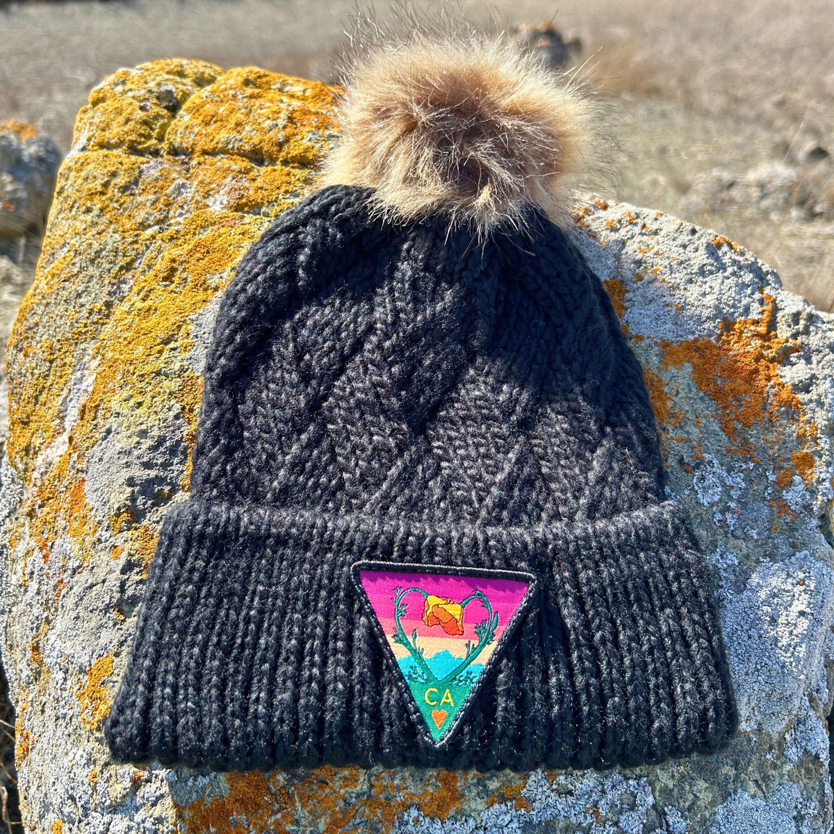 Black Kooh Culture cable knit pom beanie with the Poppy CA Love patch