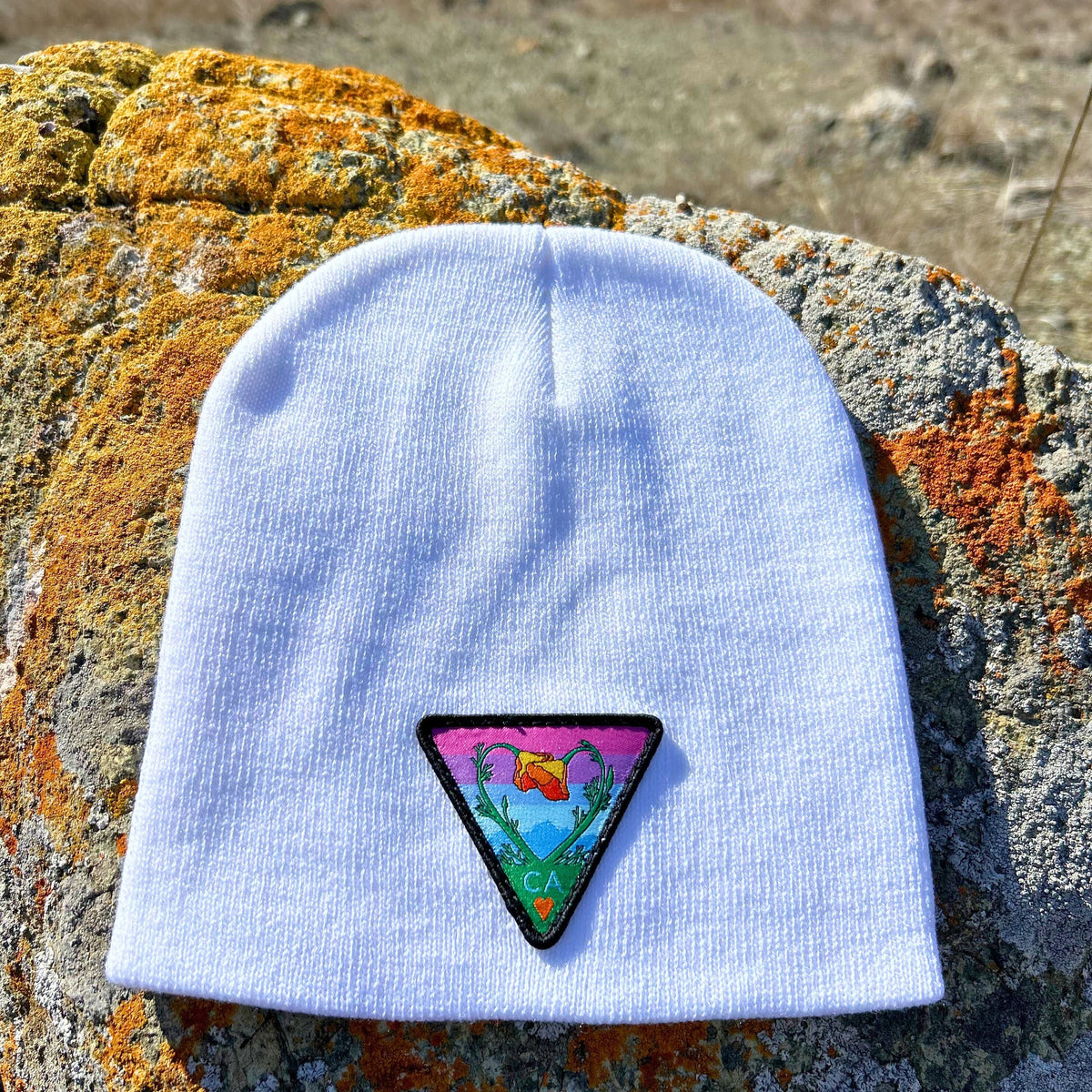White Kooh Culture cuffed beanie with the Poppy CA Love patch