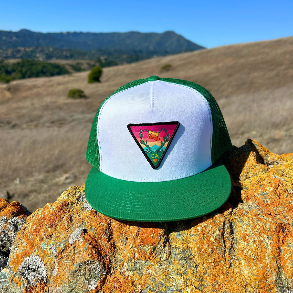 White and green Kooh Culture flat brim trucker hat with the Poppy CA Love patch