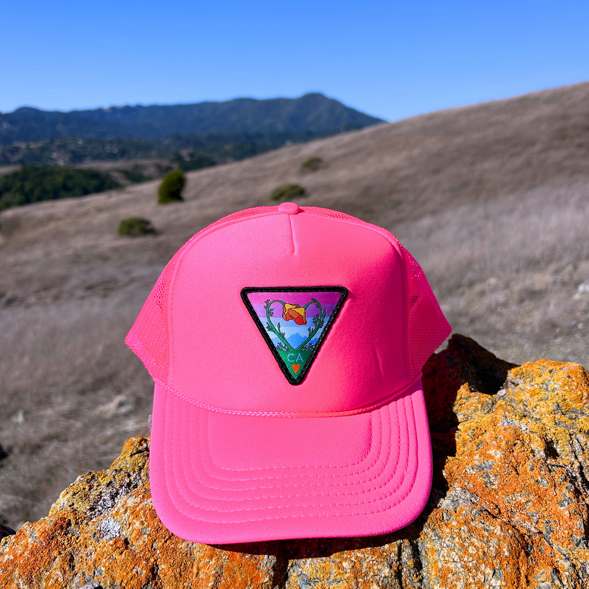 Neon pink Kooh Culture foam trucker hat with the Poppy CA Love patch