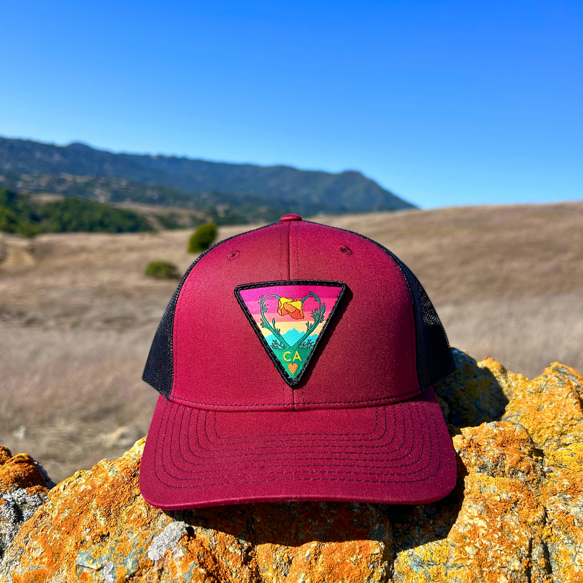 Burgundy and black Kooh Culture trucker hat with the Poppy CA Love patch
