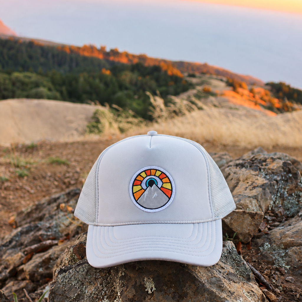 Silver and gray Kooh Culture foam trucker hat with the Evil Eye Sun patch