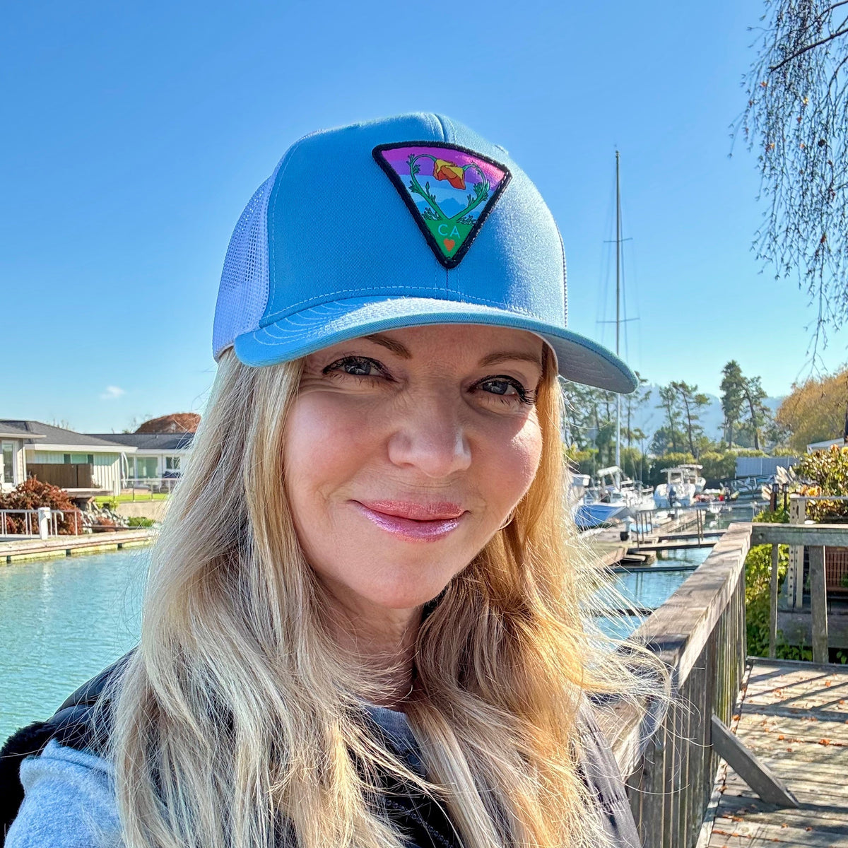 Light blue and white Kooh Culture trucker hat with the Poppy CA Love patch, alternate view