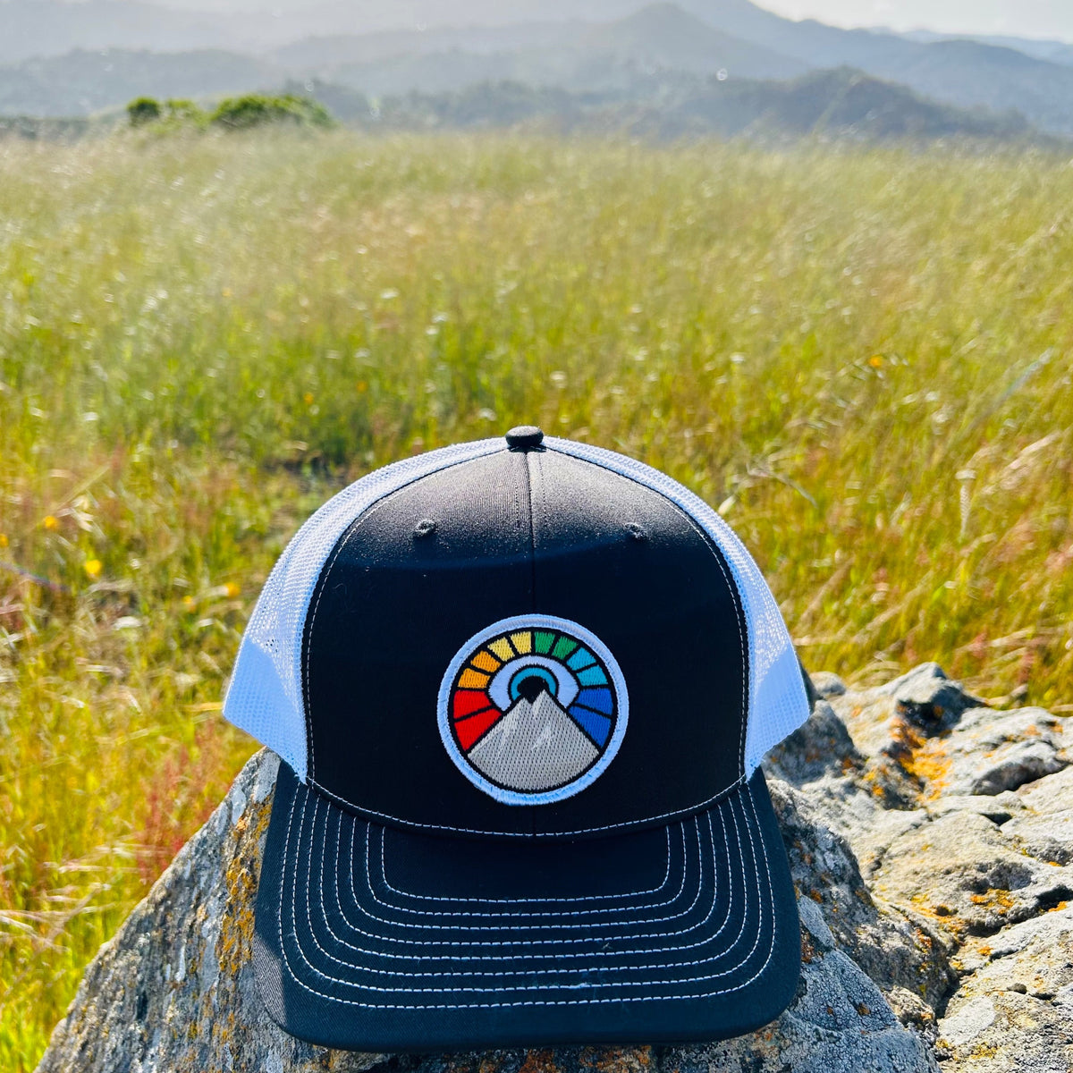 Black Kooh Culture trucker hat with the Evil Eye Sun patch in Rainbow Edition colours