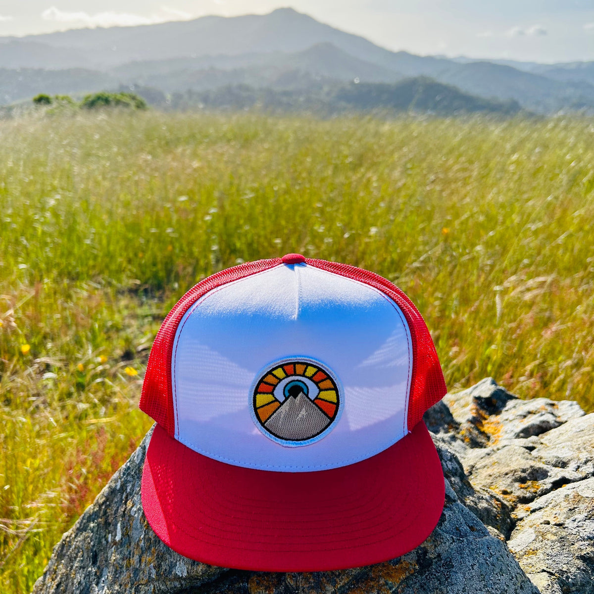 White and red Kooh Culture flat brim trucker hat with the Evil Eye Sun patch