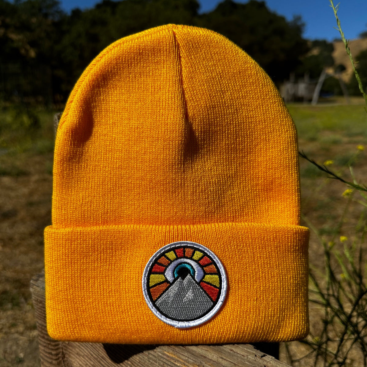 Golden yellow Kooh Culture cuffed beanie with the Evil Eye Sun patch