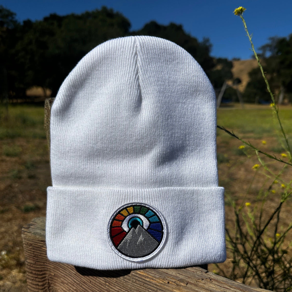 White Kooh Culture cuffed beanie with the Evil Eye Sun patch in Rainbow Edition colours