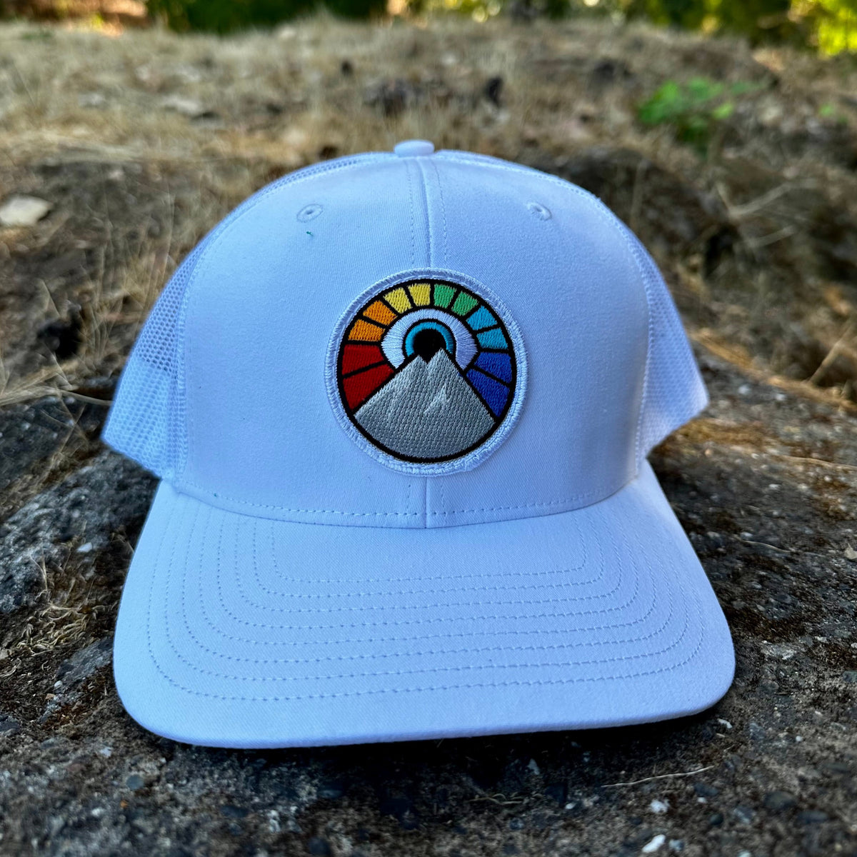 White Kooh Culture trucker hat with the Evil Eye Sun patch in Rainbow Edition colours