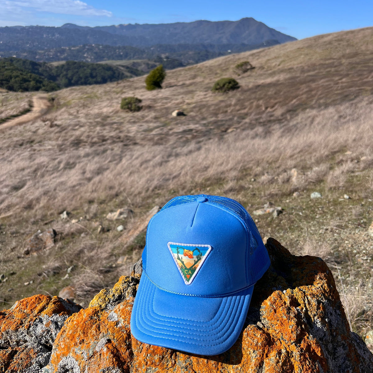 Light blue Kooh Culture foam trucker hat with the Poppy CA Love patch, alternate view