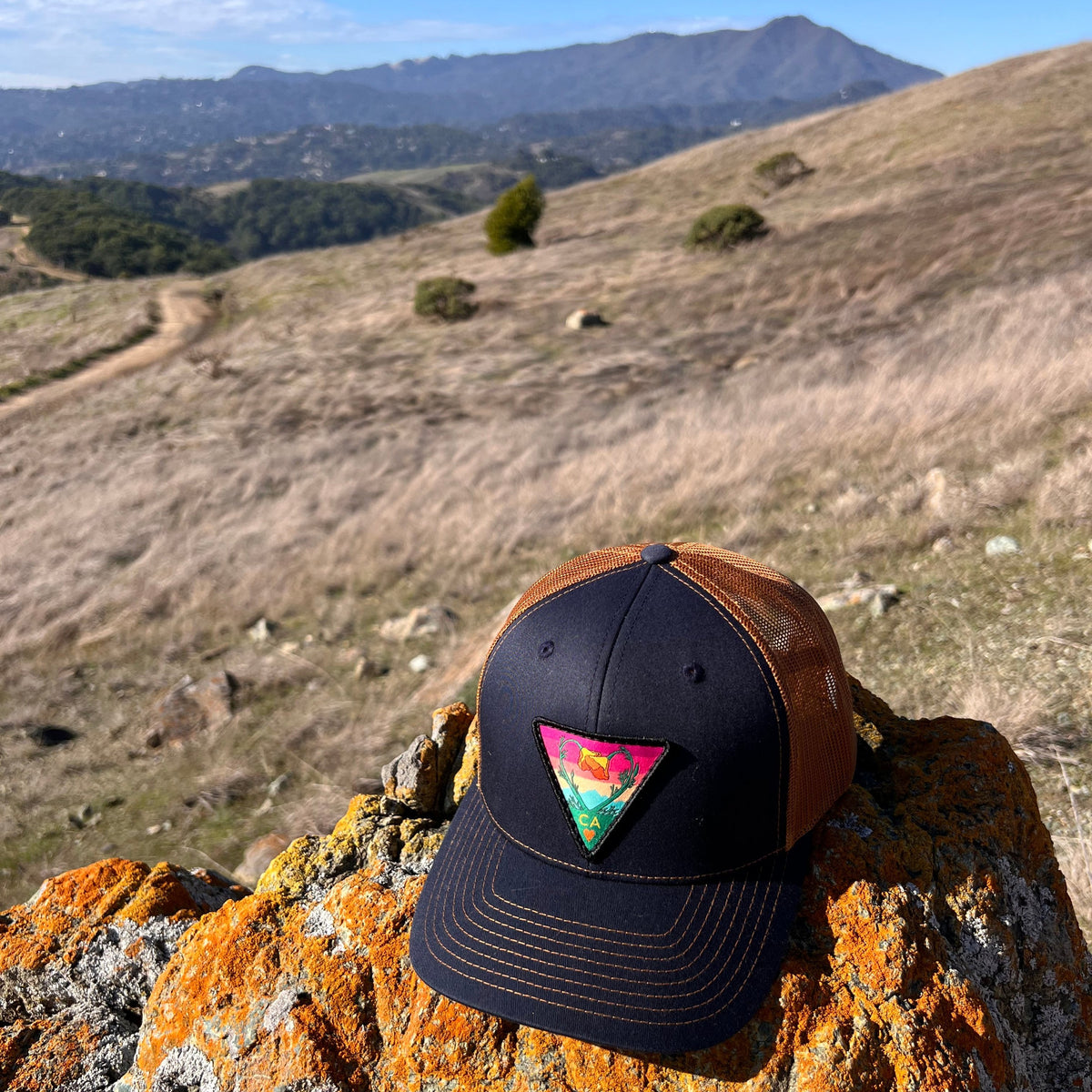 Navy and caramel Kooh Culture trucker hat with the Poppy CA Love patch, alternate view