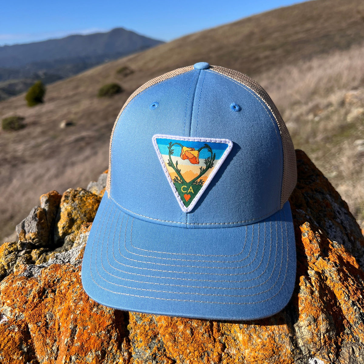 Light blue and khaki Kooh Culture trucker hat with the Poppy CA Love patch