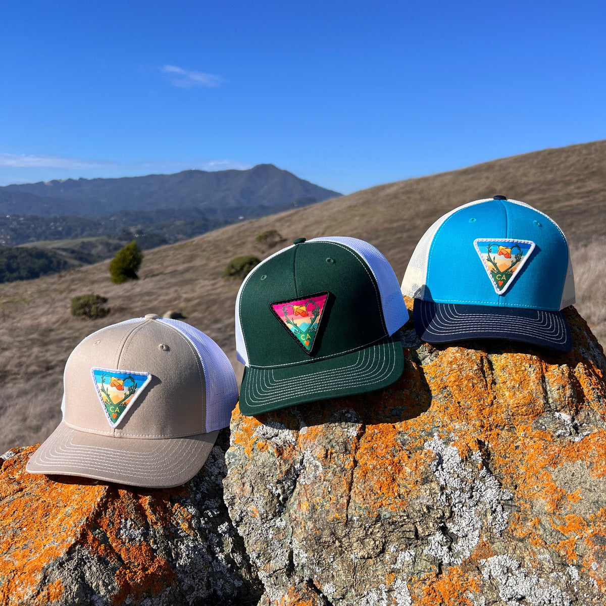 Blue teal and birch and navy Kooh Culture trucker hat with the Poppy CA Love patch, alternate view