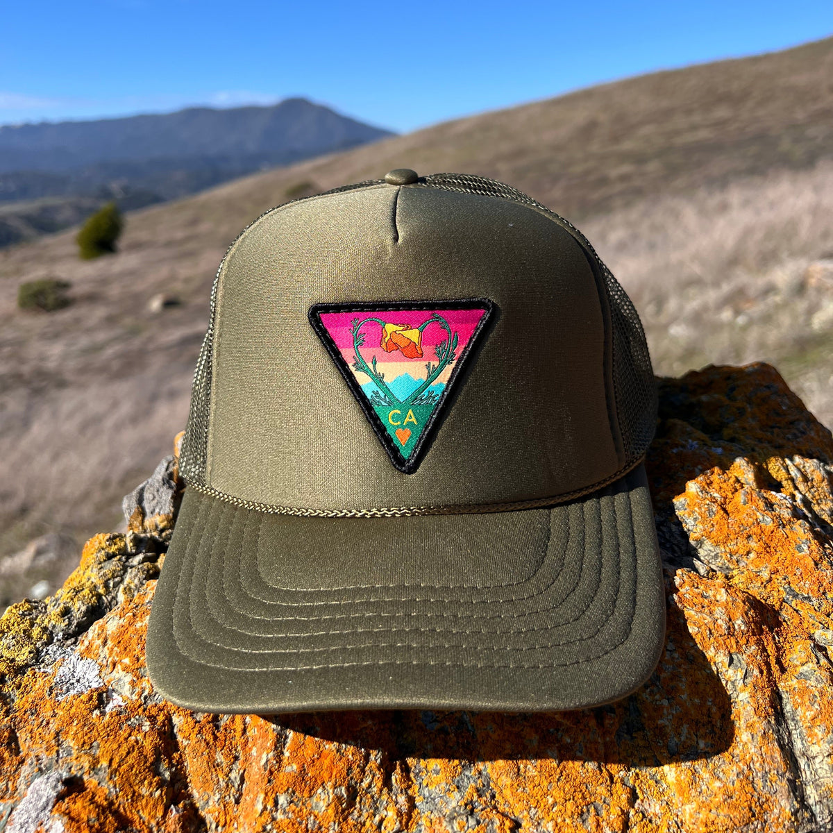 Olive green Kooh Culture foam trucker hat with the Poppy CA Love patch