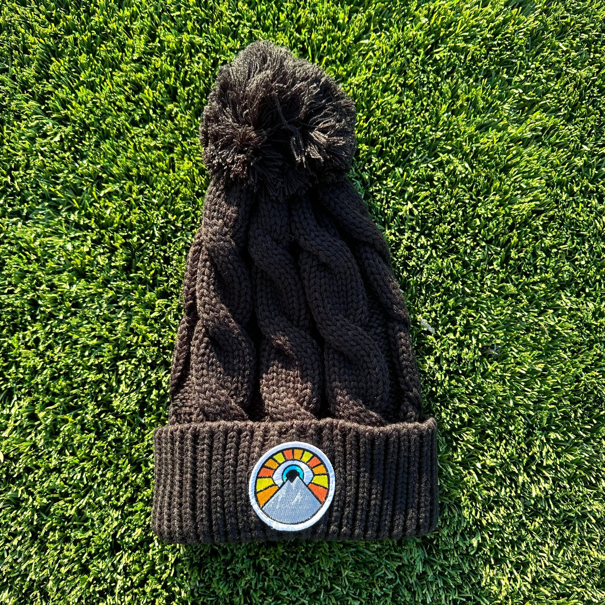 Black Kooh Culture pom beanie with the Evil Eye Sun patch