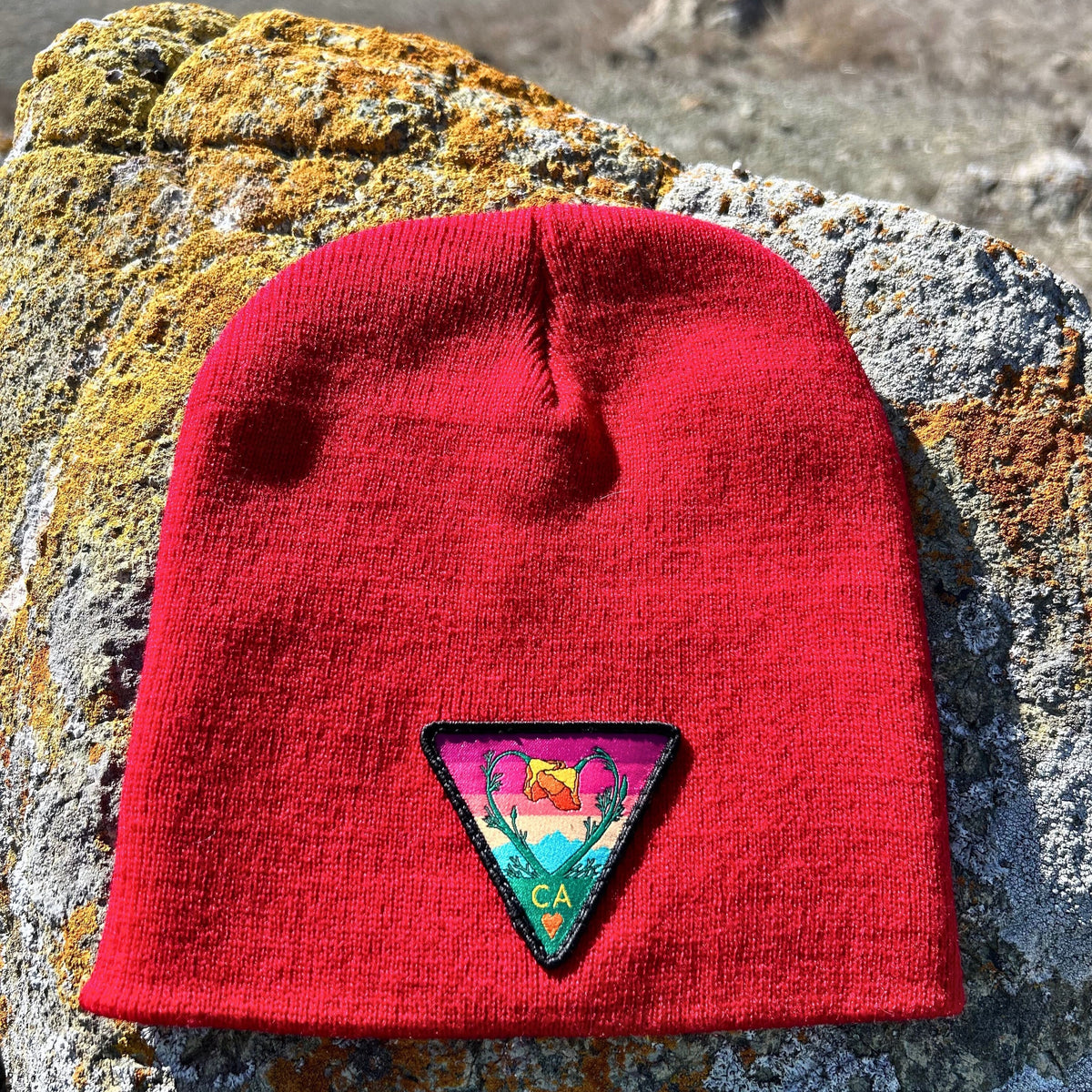 Deep red Kooh Culture cuffed beanie with the Poppy CA Love patch