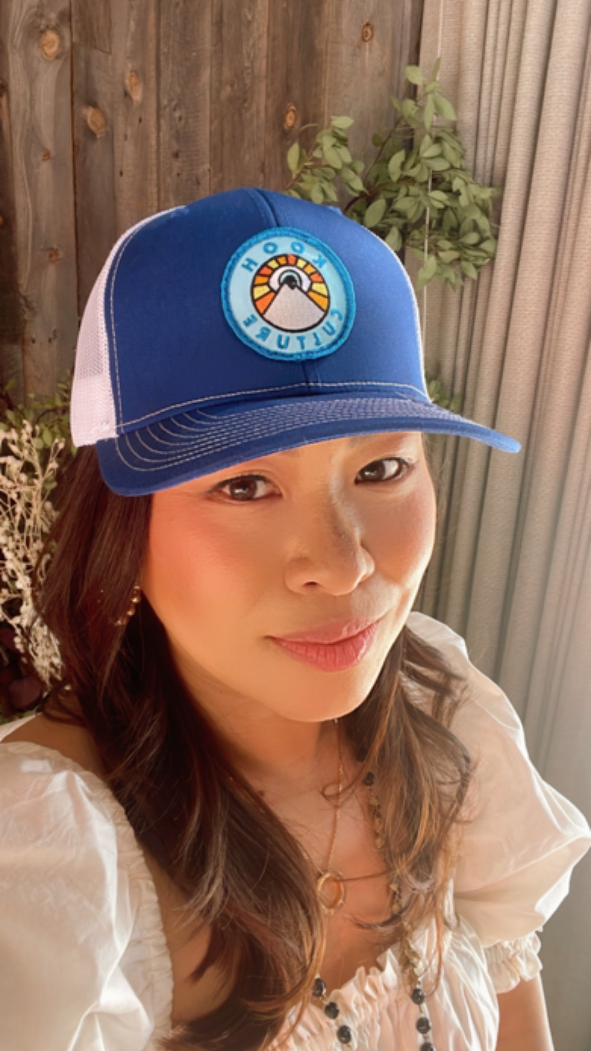 Royal blue and white Kooh Culture trucker hat with the mountain and sun badge, alternate view