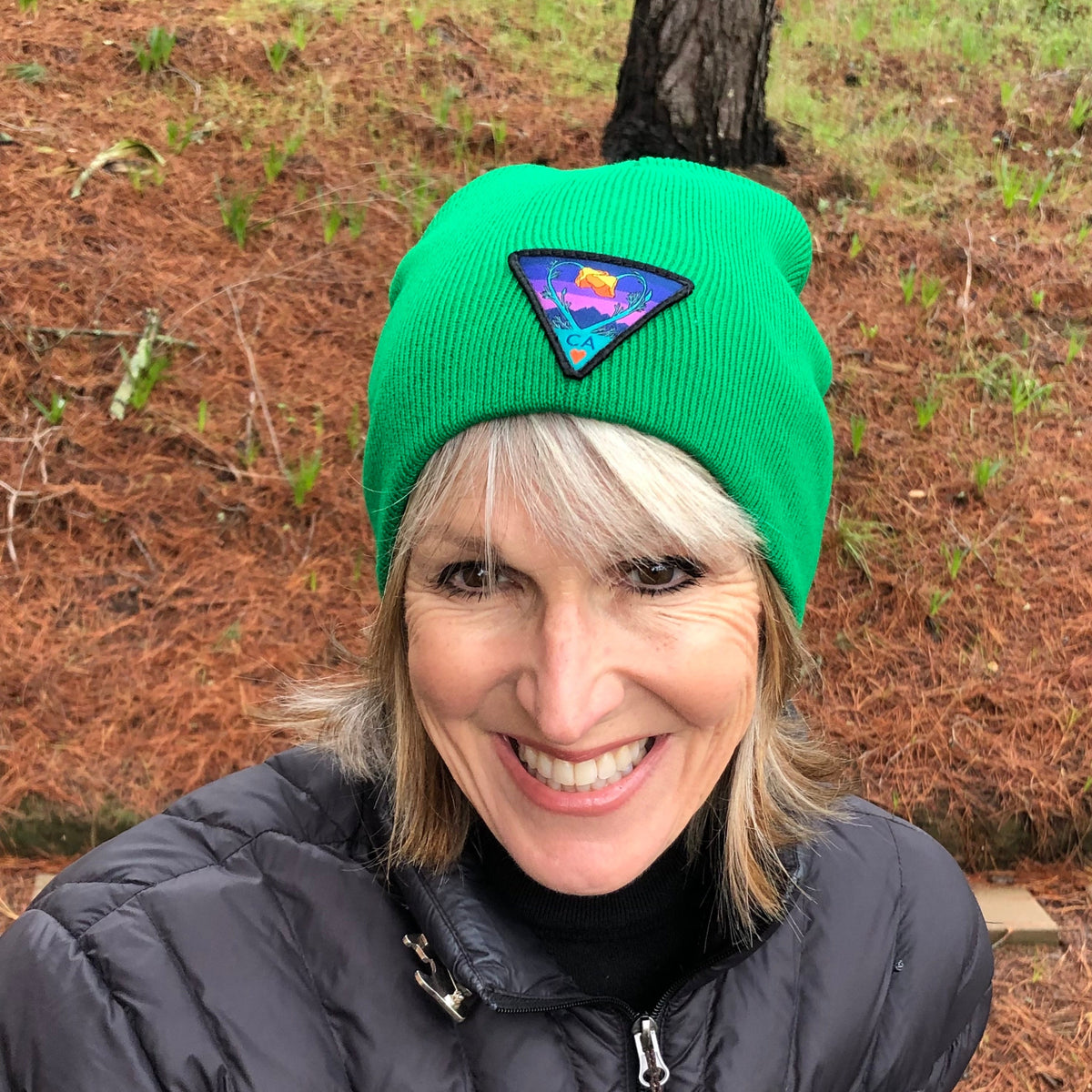 Kelly green Kooh Culture cuffed beanie with the Poppy CA Love patch in Night Mode colours