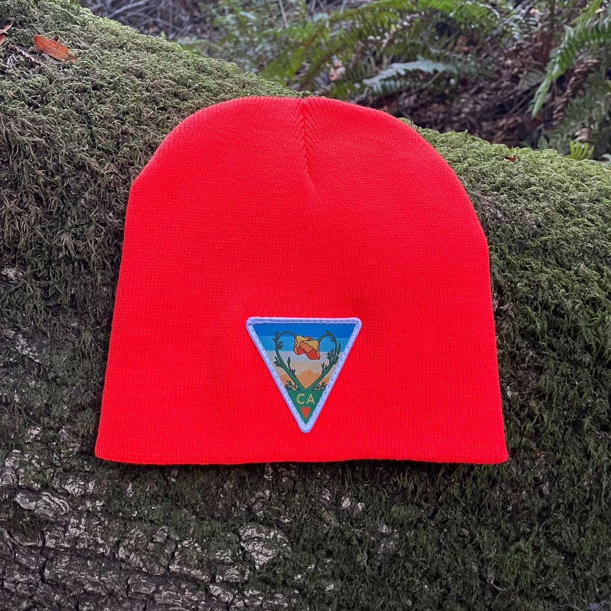 Neon orange Kooh Culture cuffed beanie with the Poppy CA Love patch