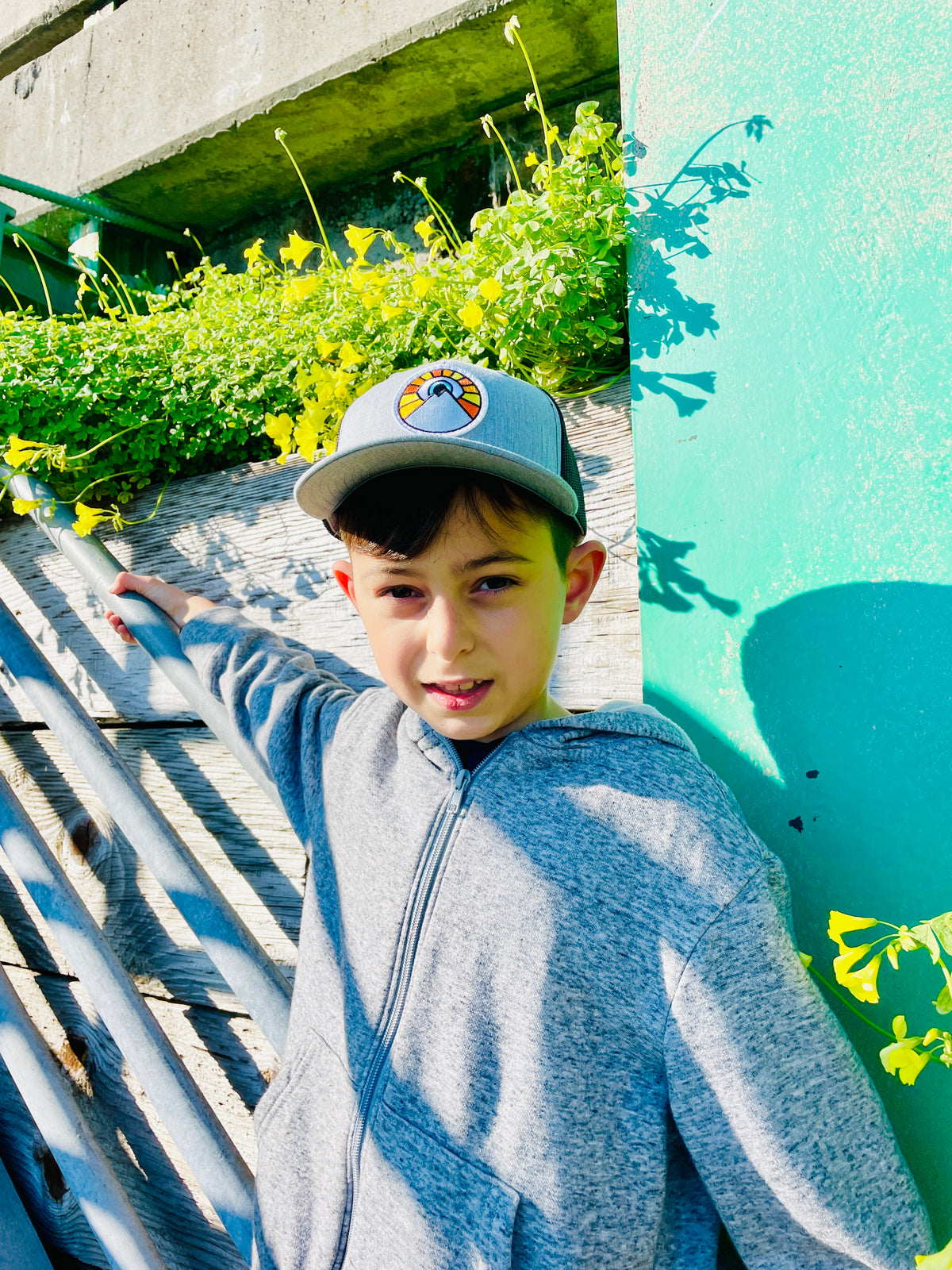 Grey and black Kooh Culture youth trucker hat with the Evil Eye Sun patch, alternate view