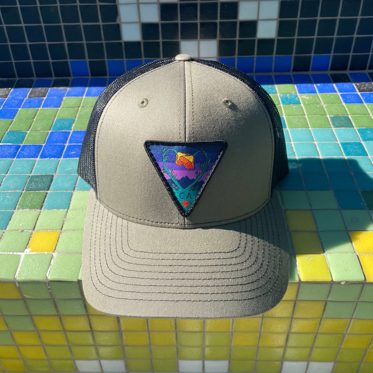 Olive and black Kooh Culture trucker hat with the Poppy CA Love patch in Night Mode colours