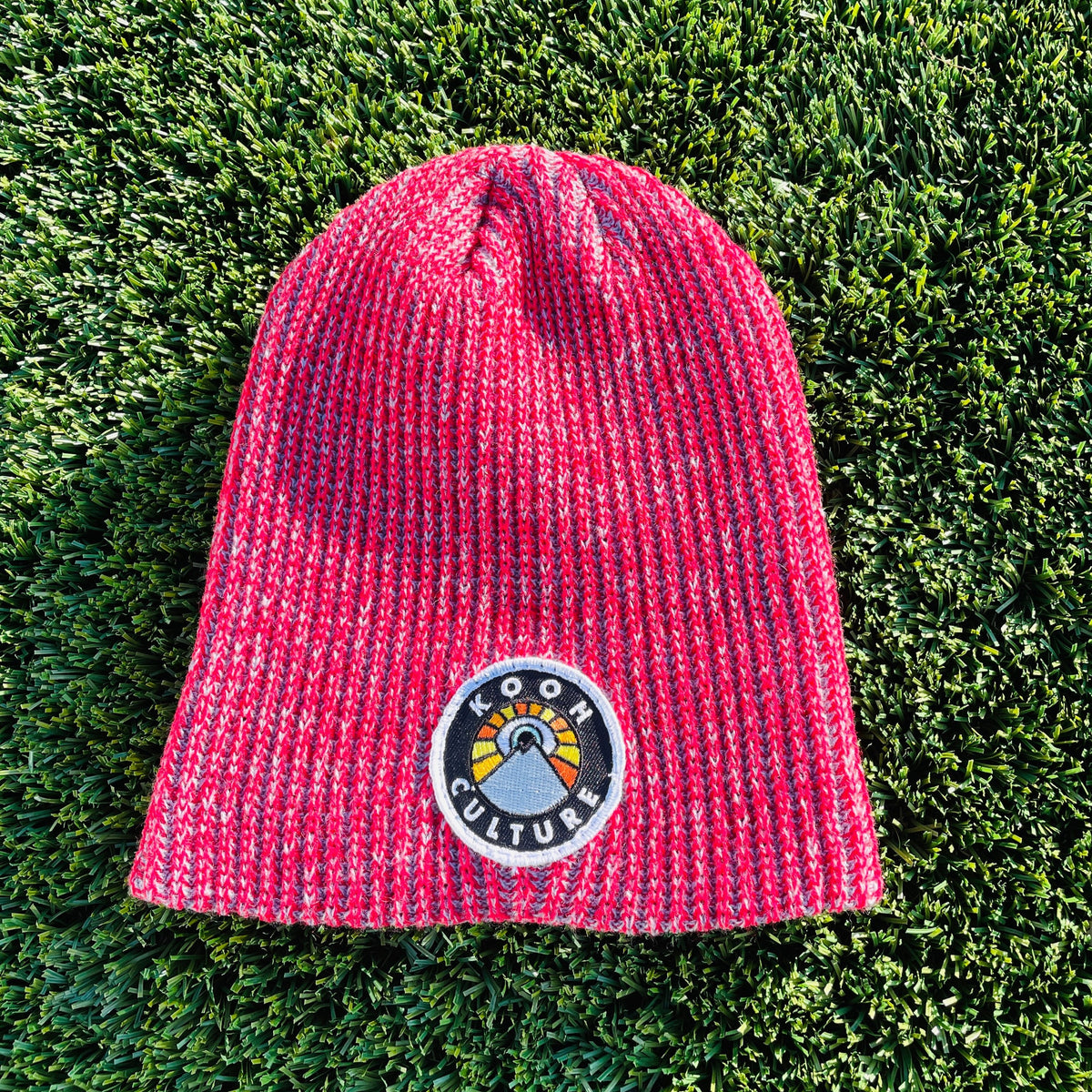 Red and grey Kooh Culture cuffed beanie with the mountain and sun badge